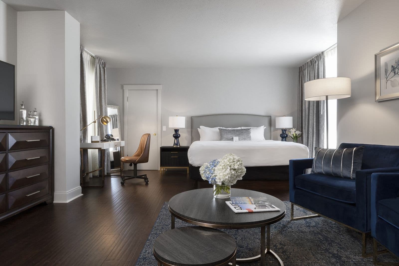 A Superior King room with a sitting area and hardwood floors