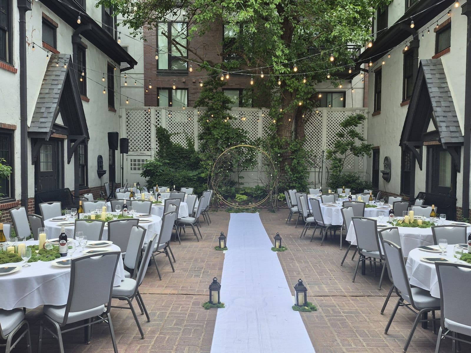 A white aisle runner through the courtyard set for a wedding